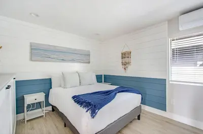 a bedroom with a bed with blue and white walls at Tower 9 Oceanview House in Oceanside