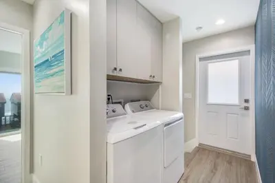 a white laundry room with a washer and dryer at Tower 9 Oceanview House in Oceanside