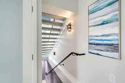 a staircase in a house with a painting on the wall at Tower 9 Oceanview House in Oceanside