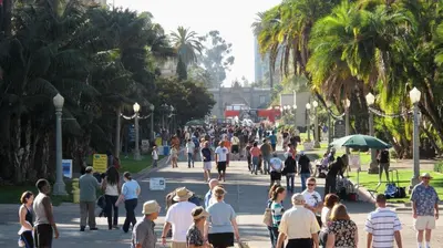 a crowd of people walking down a street with palm trees at Entire Private Studio with 1 King Bed, Full Kitchen, Gated Yard, Available Now in Spring Valley
