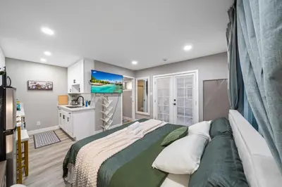 a bedroom with a large bed and a kitchen at Entire Private Studio with 1 King Bed, Full Kitchen, Gated Yard, Available Now in Spring Valley