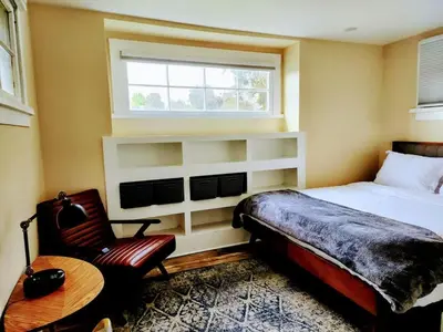 a bedroom with a bed and a chair and a window at Urban Oasis Near Downtown & Balboa Park in San Diego