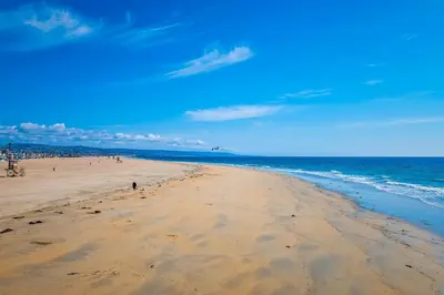 a beach with people walking on the sand and the ocean at Steps to SandParkingACGround Level in Newport Beach