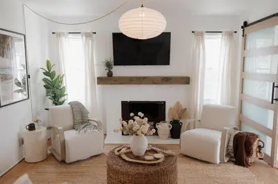 a living room with two chairs and a fireplace at Designer Bungalow Steps to Beach in San Diego