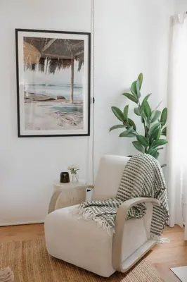 a living room with a chair and a picture at Designer Bungalow Steps to Beach in San Diego
