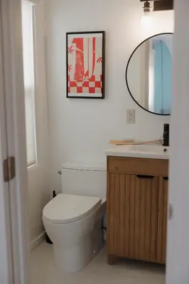 a bathroom with a toilet and a sink at Designer Bungalow Steps to Beach in San Diego