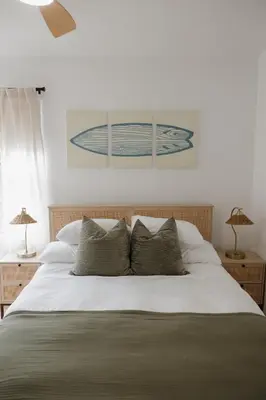 a bedroom with a large white bed with two lamps at Designer Bungalow Steps to Beach in San Diego