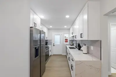 a kitchen with white cabinets and stainless steel appliances at NEW 2BR, 1BA, Outdoor Fireplace, Patio Lounge, Western Vibes, Smart TVs, Ambient Lighting in San Diego