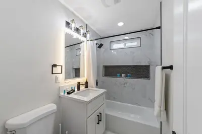 a white bathroom with a sink and a shower at NEW 2BR, 1BA, Outdoor Fireplace, Patio Lounge, Western Vibes, Smart TVs, Ambient Lighting in San Diego