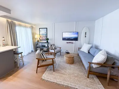 a living room with a blue couch and chairs at Fully Renovated Beachfront Surf House Oceanside in Oceanside