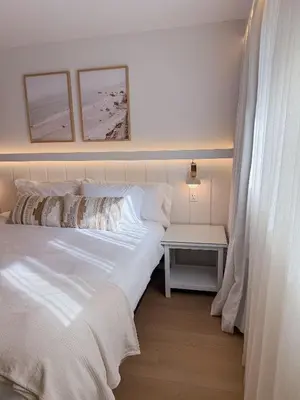 a bedroom with a white bed and a table at Fully Renovated Beachfront Surf House Oceanside in Oceanside
