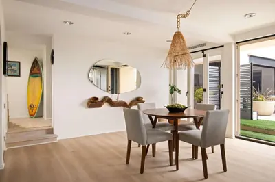 a dining room with a table and chairs and a mirror at La Jolla Private Beach Oceanfront in San Diego