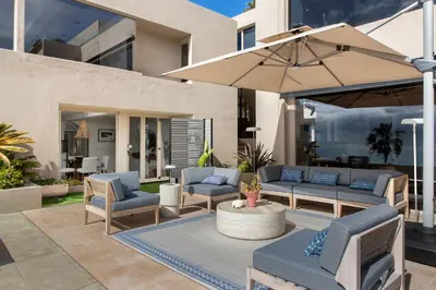 a patio with blue furniture and an umbrella at La Jolla Private Beach Oceanfront in San Diego