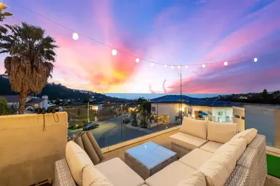 a living room with a couch on a balcony at Oceanview Luxe Retreat with Rooftop in San Diego
