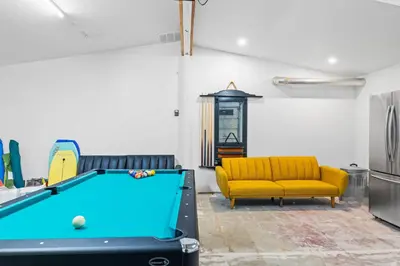 a room with a pool table and a yellow couch at Dog-Friendly House with Hot Tub, AC, Game Room in Oceanside