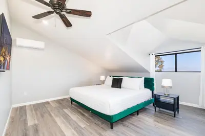 a bedroom with a bed and a ceiling fan at Sleeps 31 10br Mountain View, Pool, Spa and Games in El Cajon