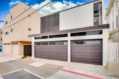 a house with two garage doors on a street at Boardwalk Studio Shared Hot Tub and Patio in San Diego