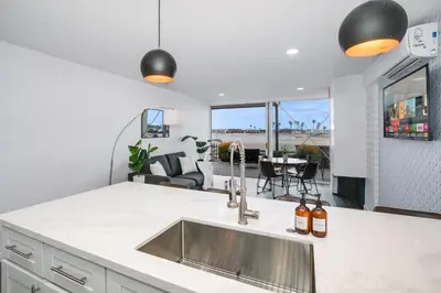 a kitchen with a sink and a view of the ocean at Beachfront Bliss Cozy 1BR Condo with Shared Perks in San Diego