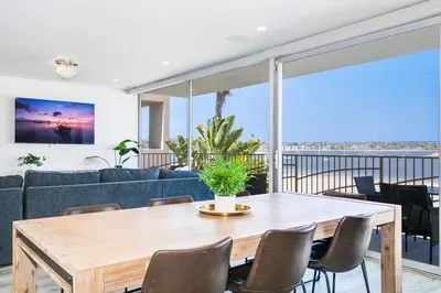 a dining room with a table and a couch at Bayfront Beauty 3BR Mission Bay Retreat in San Diego