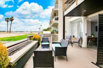 a patio with chairs and a table with a view of the ocean at Bayfront Beauty 3BR Mission Bay Retreat in San Diego