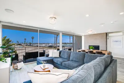 a living room with a blue couch and a table at Bayfront Beauty 3BR Mission Bay Retreat in San Diego