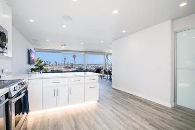 a kitchen with white cabinets and a view of the city at Bayfront Beauty 3BR Mission Bay Retreat in San Diego