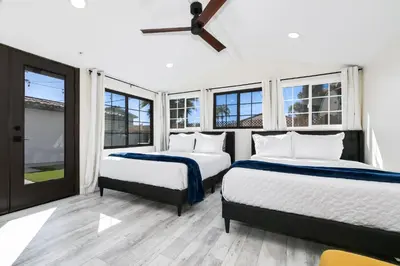 two beds in a room with windows at Luxury Oasis with Ping Pong, Firepit and Cozy Patio in San Clemente