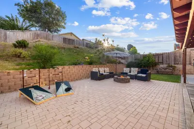a patio with two couches and an umbrella at Spacious 4BR Oasis with Pool Table and Spa in San Diego