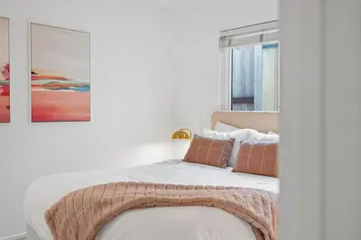 a white bedroom with a bed with a blanket on it at Spacious 4BR Oasis with Pool Table and Spa in San Diego