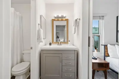 a bathroom with a sink and a toilet and a mirror at Spacious 4BR Oasis with Pool Table and Spa in San Diego
