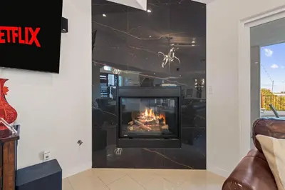 a living room with a fireplace in the wall at Modern La Jolla Escape Pool Rooftop Views in San Diego