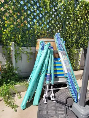 a pile of umbrellas sitting on top of a cart at #753Coastal Anchor Suite!GroundLevel/Parking/Grill in San Diego