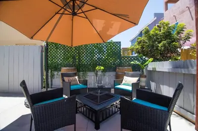 a patio with a table and chairs and an umbrella at #753Coastal Anchor Suite!GroundLevel/Parking/Grill in San Diego
