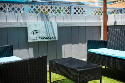 a group of chairs and tables with an umbrella sign at #755 2B2B Beach Getaway!Ground Level w/Patio&Grill in San Diego