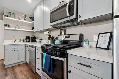 a kitchen with white cabinets and a stove top oven at #763 Steps from the Sand -2b2b Laundry Parking AC in San Diego
