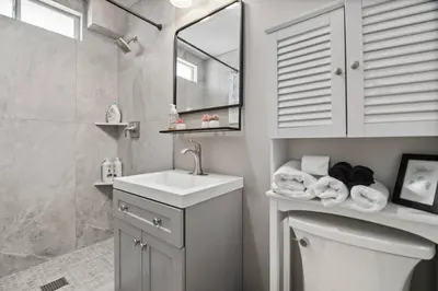 a bathroom with a sink and a toilet and a mirror at #763 Steps from the Sand -2b2b Laundry Parking AC in San Diego