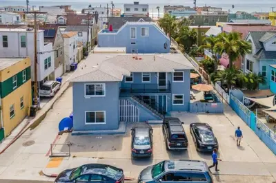 a blue house with cars parked in a parking lot at #763 Steps from the Sand -2b2b Laundry Parking AC in San Diego