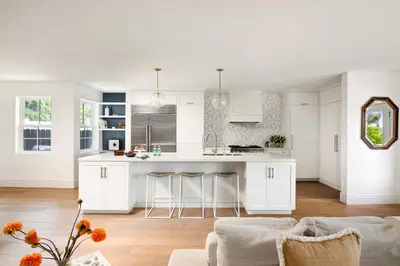 a white kitchen with white cabinets and a kitchen island at Modern Coastal La Jolla Gem in San Diego