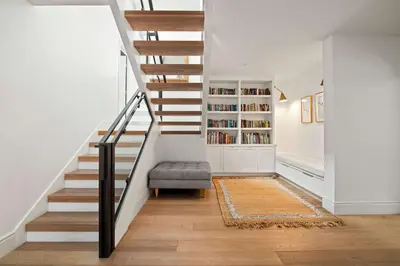 a staircase in a home with a chair and a book shelf at Modern Coastal La Jolla Gem in San Diego