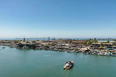 a small boat in the water next to a marina at Balboa Island Cottage Air Conditioning Ferry Close in Newport Beach