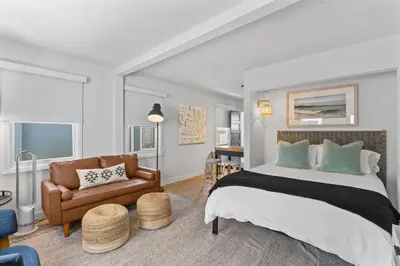 a bedroom with a large bed and a couch at Balboa Island Cottage Air Conditioning Ferry Close in Newport Beach