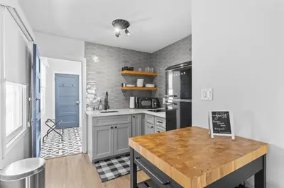 a kitchen with gray cabinets and a wooden table at Balboa Island Cottage Air Conditioning Ferry Close in Newport Beach
