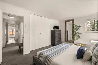 a white bedroom with a bed and a dresser at Seize the Day in San Diego