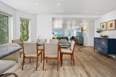a dining room and living room with a table and chairs at Surf Song Symphony - SONG55 in Solana Beach