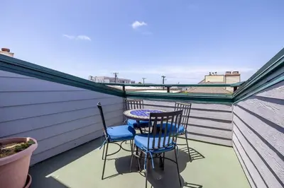 a patio with two chairs and a table on a balcony at Steps From the Beach & Belmont in San Diego