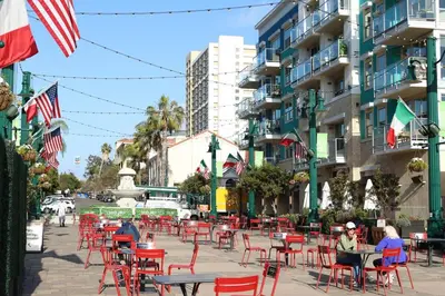 a street with red chairs and tables and flags at Ocean View Loft in Little Italy near Downtown-Gaslamp in San Diego