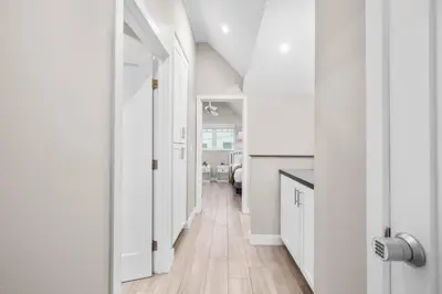 a hallway of a home with white walls and wooden floors at Ocean Breeze and Rooftop Views Steps to Surf and Sun in San Diego