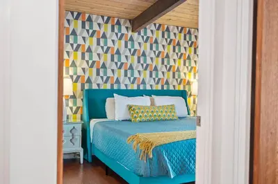 a bedroom with a blue bed with a geometric wallpaper at Luxury Hilltop Stay Pool, Firepit and Views in La Mesa