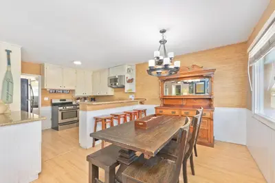 a kitchen with a wooden table and a dining room at Costa del Sol in Newport Beach