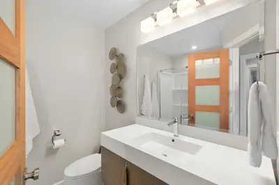 a white bathroom with a sink and a toilet at Solana Beach Escape, Beach Access, AC, Pools, Spa, Tennis Courts & Clubhouse Views in Solana Beach